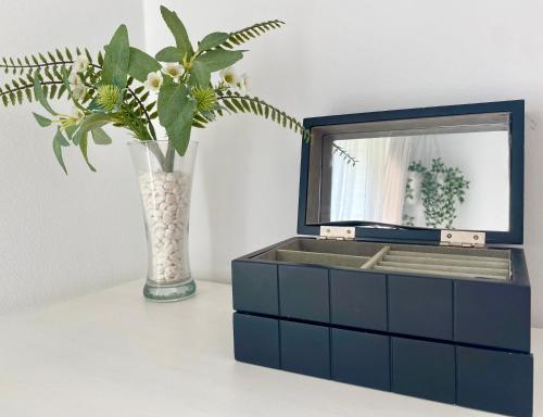 a blue dresser with a mirror and a vase with a plant at Apartamento Atlántico in Rota