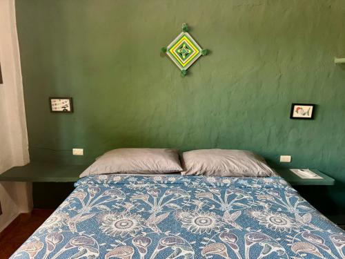 a bedroom with a bed with a green wall at Refugio del Cielo # in Sayulita