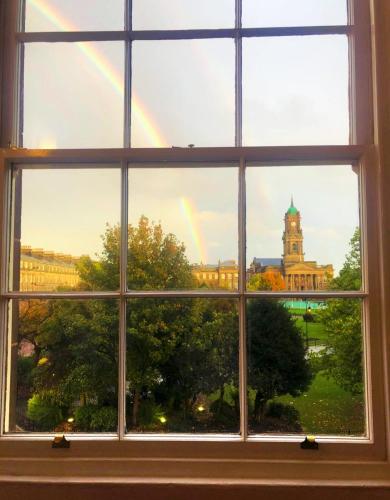 a window with a view of a building with a rainbow at Elegant Apartment In Hamilton Square Free Parking in Birkenhead