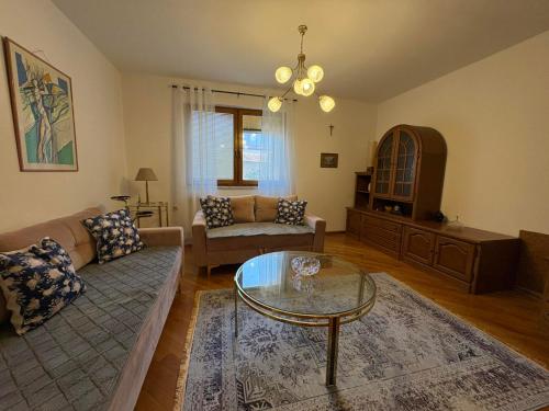 ein Wohnzimmer mit einer Couch und einem Glastisch in der Unterkunft Casa Bella Stup in Sarajevo