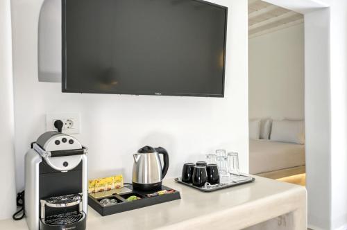 a kitchen counter with a blender and a tv on the wall at Paolas Sunset in Agios Stefanos