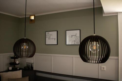 two lights hanging from a wall with two pictures at Ferienhaus Hallmanns Hof in Schmallenberg