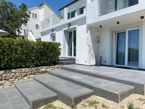 a house with stairs leading to the front door at Apartment Dubravko mit Meerblick 100 m Strand, Parking in Maslenica