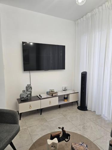 a living room with a flat screen tv on the wall at Modern 3BR Apmt Near Airport & Beach in San Isidro