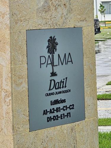 a sign for a hotel with a palm tree at Modern 3BR Apmt Near Airport & Beach in San Isidro