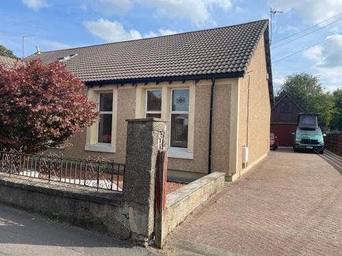 a small brick house with a driveway at Quirky Cottage Central Bathgate in Bathgate