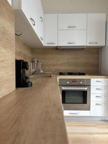 a kitchen with white cabinets and a stainless steel oven at PA - Peaceful Parkside Apartment in KoÅ¡ickÃ© KÃºpele