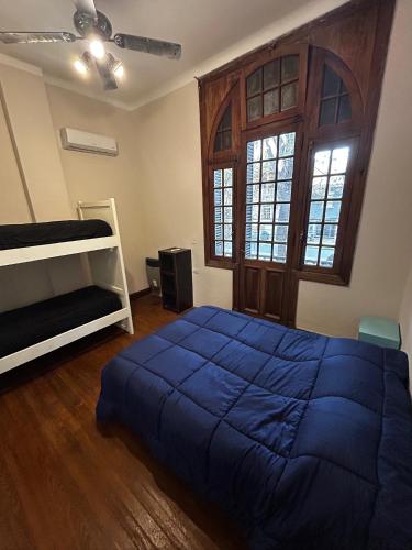 a bedroom with a blue bed and a window at Hostel Plaza in Mendoza