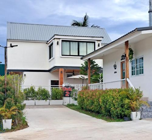 a white house with a gate and a driveway at Near Khao yai National Park tour and taxi services in Mu Si
