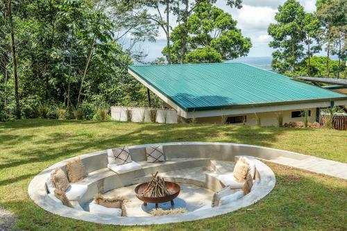 a fire pit in a yard in front of a house at Pandanus Lodge & Retreats Bungalow Gingiber in Cariblanco