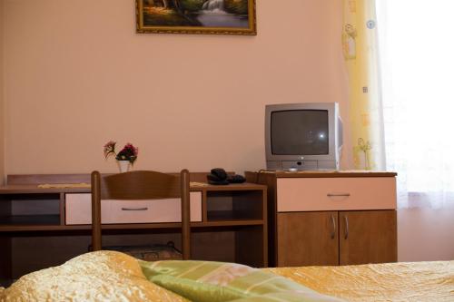 a living room with a tv and a table with a chair at Guest house Bohorč in Šentjur
