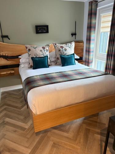a bedroom with a large bed with blue pillows at The Wee Bothy in Oban