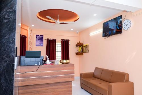 a waiting room with a couch and a tv at SANGAM RESIDENCY Manipal in Manipala