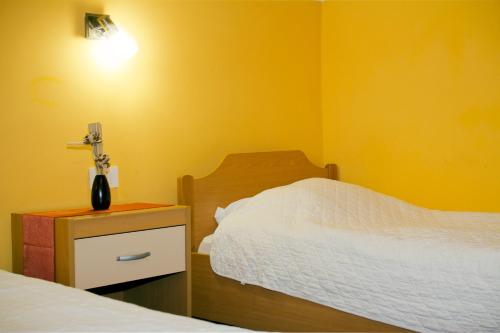 a bedroom with two beds and a vase on a night stand at Guest house Bohorč in Šentjur