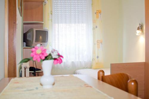 a vase with pink flowers sitting on a table at Guest house Bohorč in Šentjur