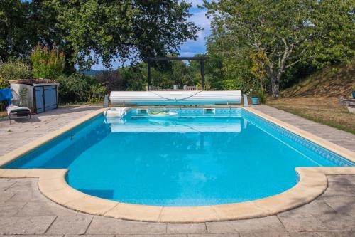 une piscine avec de l'eau bleue dans une cour dans l'établissement Jasmin Cottage, à Montayral