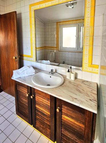 a bathroom with a sink and a mirror at Sea Twins Villas in Praia de Mira