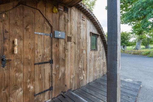 un edificio in legno con una grande porta in legno di Pod2 - Powys River Pods - Pet Friendly Glamping Pod Builth Wells Powys Wales a Garth