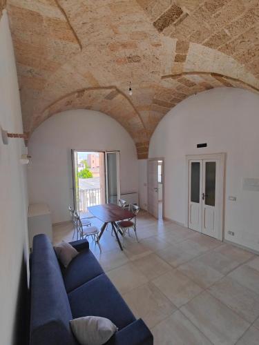 a living room with a blue couch and a table at Borgo Antico Guest House in Ruffano