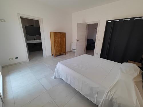 a bedroom with a white bed and a bathroom at Borgo Antico Guest House in Ruffano