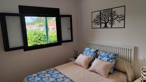 a bedroom with a bed and a window at A Devesa in Noya