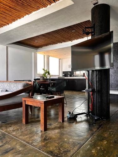 a living room with a fireplace and a wooden table at Condominio Agave del Mar in Coyuca
