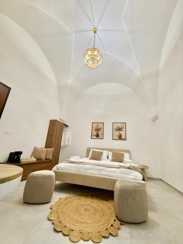 a bedroom with a large bed and a chandelier at La dimora degli ulivi in Torre Santa Susanna