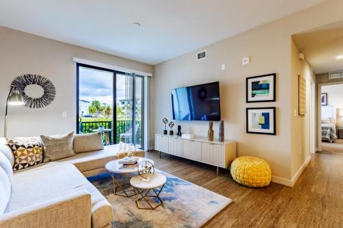 a living room with a couch and a tv at Fort Myers 2BR Condo Pool BBQ Area in Estero