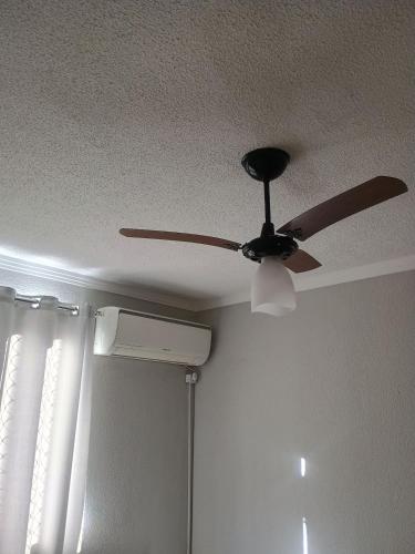a ceiling fan in a room with a window at La Bela Casa in Catanduva