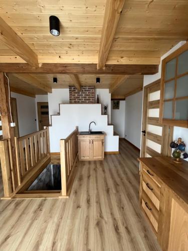 a large room with wooden ceilings and a sink at Siedlisko pod Lasem in Józefów