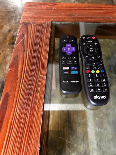two remote controls sitting on top of a wooden bench at Condominio Agave del Mar in Coyuca