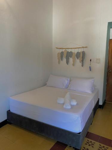 a bed with white sheets and pillows in a room at Traveler Hostel in San Gil