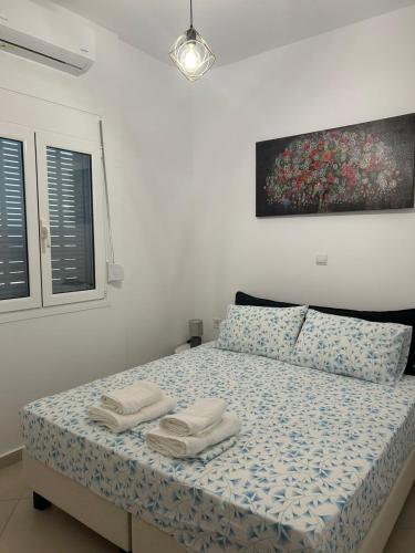 a bedroom with a bed with two towels on it at Οι δίδυμες σουίτες in Nafpaktos