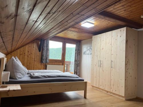 a bedroom with a bed and a wooden ceiling at Ferienwohnungen am Pietschacherhof in Hochrindl