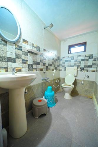 a bathroom with a sink and a toilet at Elephant path Coorg villas in Suntikoppa