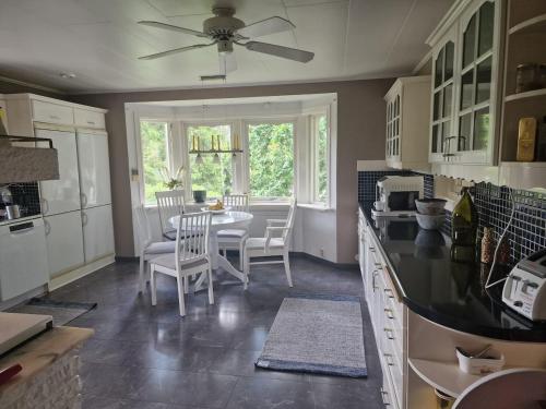 a kitchen with a table and chairs and a window at Peaceful villa in nature with own beach in Hindås