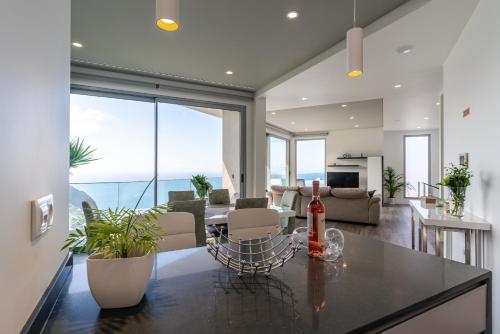 a living room with a table with a bottle of wine at Villa António in Arco da Calheta