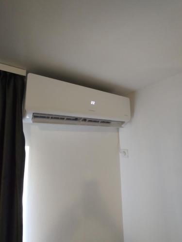 a white air conditioner in a room with a curtain at Studio Vata in Vaţa de Jos