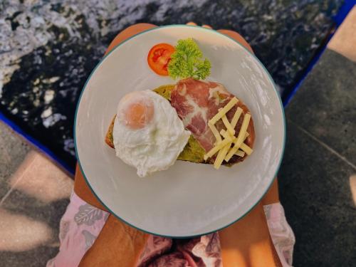 a person holding a plate with a plate of food at mata villas gili trawangan in Gili Trawangan