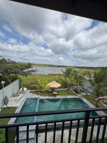 a swimming pool with a view of a body of water at Dikkale Lakefront Villa in Pannala