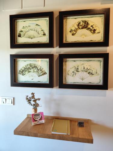 a wall with four framed pictures on a wall with a table at Lebari in Bérriz