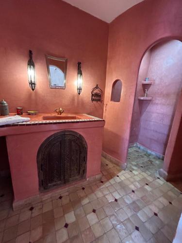 a bathroom with a sink and a fireplace at Riad Dar Bergui in Ouarzazate