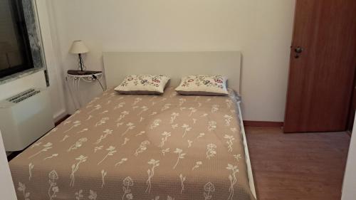 a bed with two pillows on it in a room at Apartamento Bela Vista in Pereira