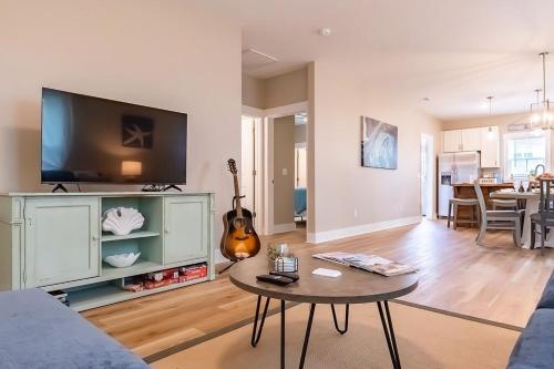 a living room with a table and a tv at Pet Friendly Cottage Near Historic Downtown & ILM in Wilmington