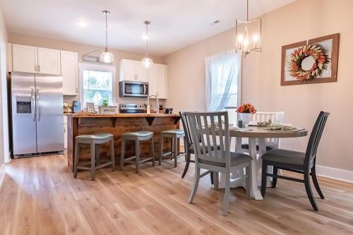 a kitchen with a table and chairs and a refrigerator at Pet Friendly Cottage Near Historic Downtown & ILM in Wilmington