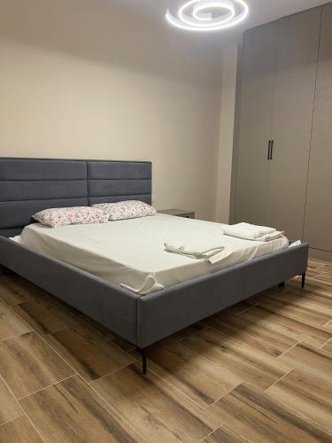 a large bed in a room with a wooden floor at SeaSide Escape in Durrës