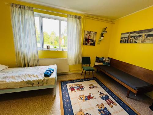 a bedroom with yellow walls and a bed and a rug at Torgu Royal Guesthouse in Iide