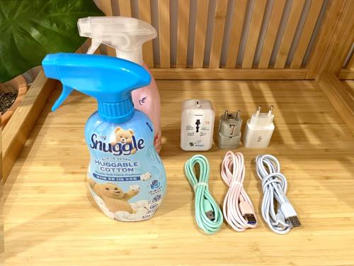 a bottle of snuggles water and a pair of scissors at Hongdae Station Link House with Massage Chair in Seoul