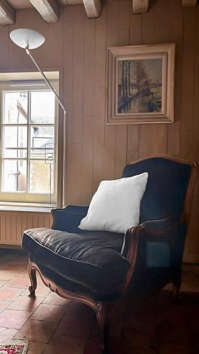 a blue chair with a pillow on it in a room at L'eau Vive demeure de charme in Mer