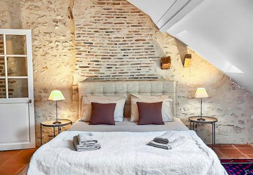 a bedroom with a large white bed with two lamps at L'eau Vive demeure de charme in Mer